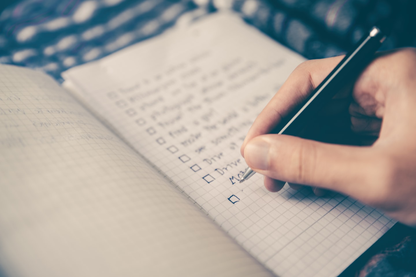 Person writing a checklist in a notebook symbolizing planning and the time doesn’t care philosophy